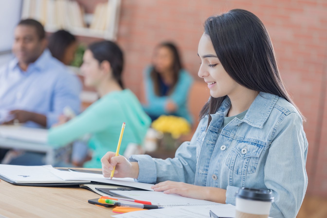 Independent college student works on paper in the student center